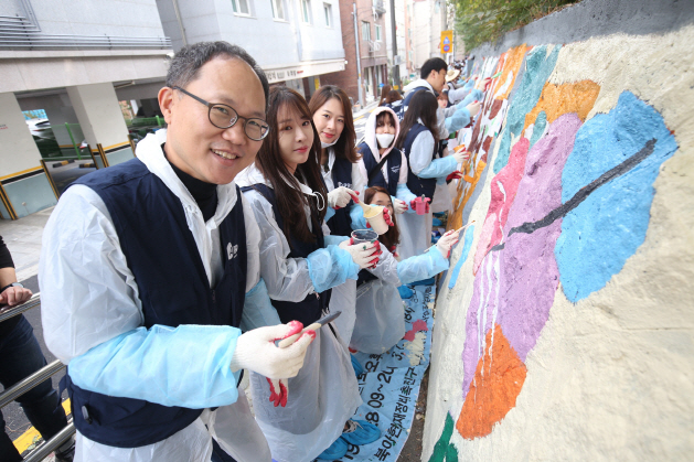 OK금융그룹 임직원들이 서울 양동초등학교에서 벽화 그리기를 하고 있다./사진제공=OK금융그룹
