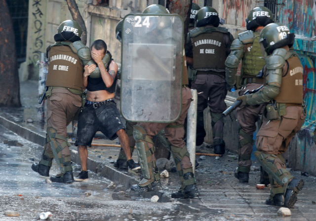 지난 16일(현지시간) 칠레 산티아고에서 반정부 시위 도중 보안군이 시위 참가자를 연행하고 있다. /산티아고=로이터연합뉴스