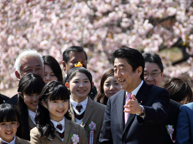 아베 신조 일본 총리가 지난 2014년 4월 12일 도쿄에서 열린 벚꽃 놀이 행사에 참가한 학생들과 이야기를 하고 있다. 아베 총리는 정부 주관인 이 행사에 자신의 선거구민을 매년 초청하는 등 사적으로 행사를 이용한 것으로 드러나면서 지지율 하락 등 정치적 위기를 맞고 있다. /블룸버그 자료사진