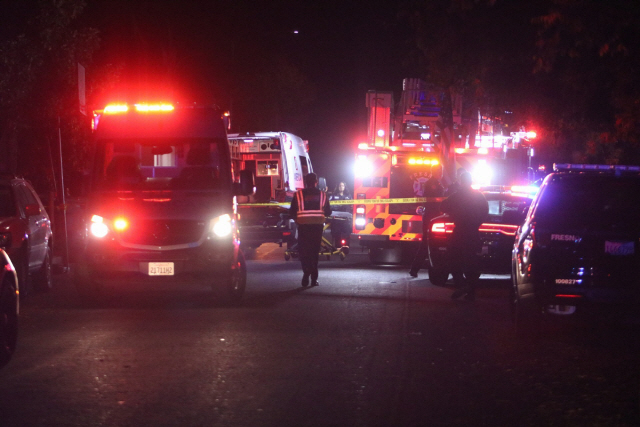 총격 사건이 발생한 미국 캘리포니아주 프레즈노의 주택가에서 17일(현지시간) 경찰과 응급구조팀이 현장을 수습하고 있다./프레즈노=AP연합뉴스