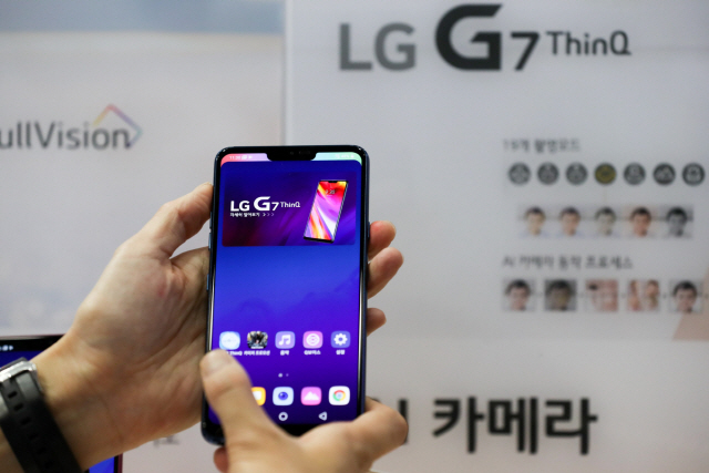 지난해 5월 23일 서울에서 열린 월드 IT쇼에서 직원이 LG전자의 G7 ThinQ 휴대전화를 들어보이고 있다. /서울=블룸버그