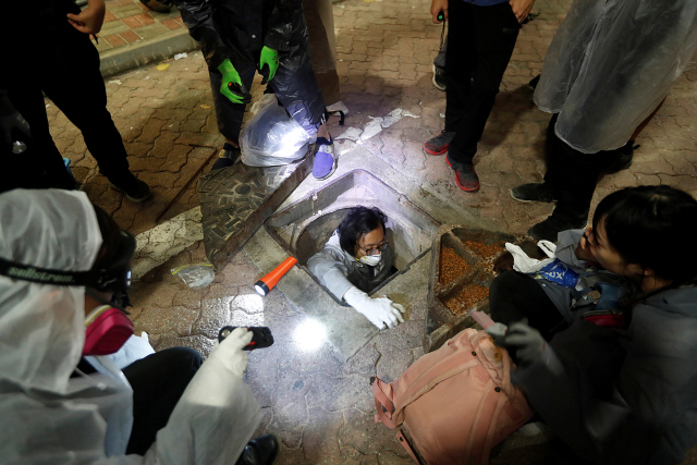 한 시위자가 하수도 터널을 통해 홍콩대 이공계 교정에서 탈출을 시도하고 있다/REUTERS=연합뉴스