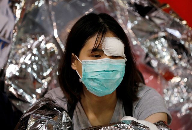 홍콩대 이공계 교정(홍콩 폴리테크닉 대학교 캠퍼스)에서 한 시위자가 의료팀을 기다리며 앉아있다./REUTERS=연합뉴스