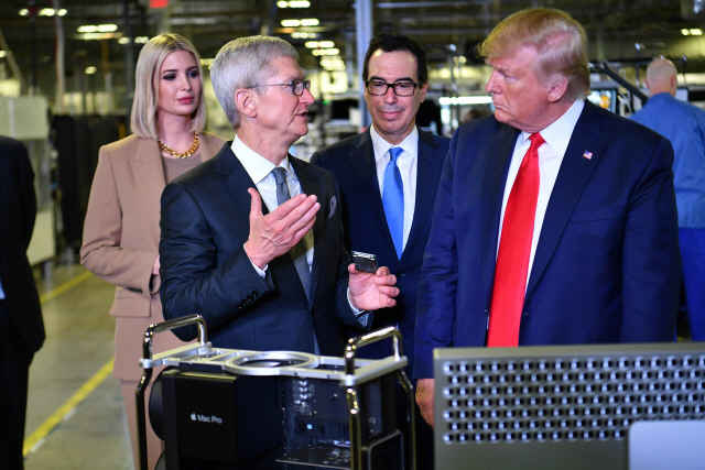 도널드 트럼프(앞 줄 오른쪽) 미국 대통령이 20일(현지시간) 미국 텍사스주 오스틴에 있는 애플 공장을 방문해 팀 쿡(앞 줄 왼쪽) 애플 최고경영자(CEO)로부터 설명을 듣고 있다./오스틴=AFP연합뉴스