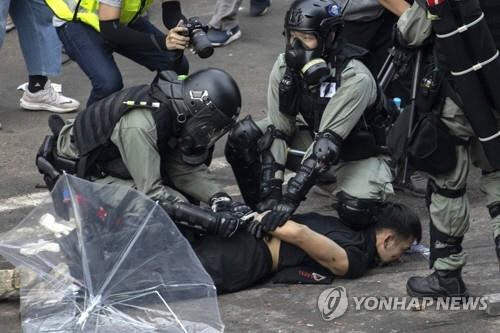 홍콩 경찰이 18일 홍콩이공대학에 진입, 한 시위자의 손을 결박하고 있다. /연합뉴스
