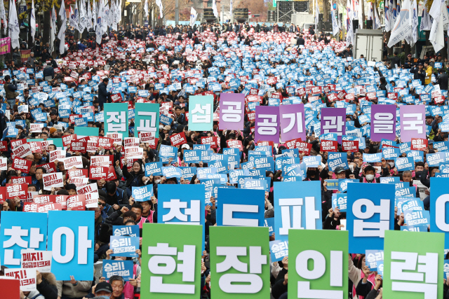 지난 23일 서울 종로구 우정국로에서 열린 공공운수노조 결의대회에서 철도노동자들이 피켓을 들고 구호를 외치고 있다./연합뉴스