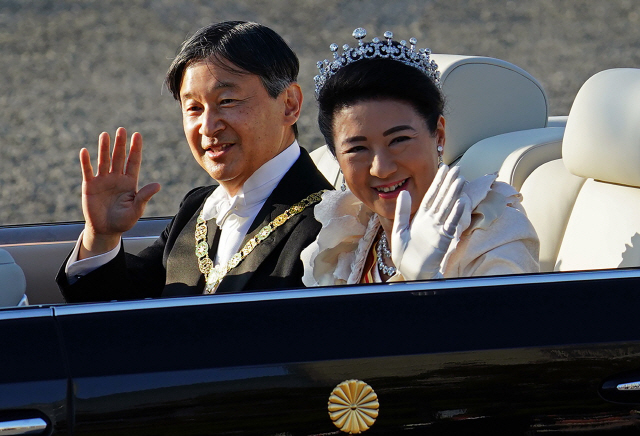 나루히토 일왕과 마사코 왕비가 지난 10일 도쿄에서 카퍼레이드를 하며 시민들에게 손을 흔들고 있다./도쿄=AP연합뉴스