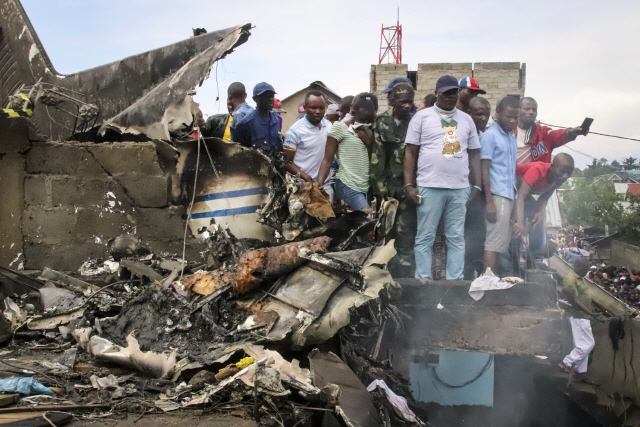 24일(현지시간) 아프리카 콩고민주공화국의 동부도시 고마에서 주민들이 추락으로 처참히 부서진 소형 비행기의 잔해를 바라보며 망연자실해하고 있다. 외신에 따르면 이 사고로 비행기 탑승자들과 지상에 있던 주민 등 최소 24명이 숨졌다.  /고마=AP연합뉴스