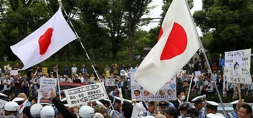 일본 가나가와(神奈川)현 가와사키(川崎)시의 한 거리에서 우파로 추정되는 인물들이 한국에 대한 혐오 감정을 조장하는 피켓과 일장기 등을 들고 행진을 시도하고 있다./연합뉴스