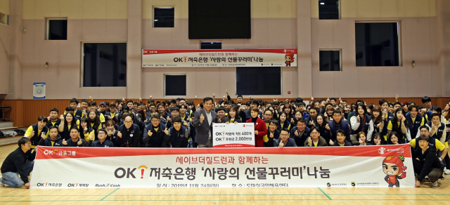 정길호(앞줄 왼쪽 아홉번째) OK저축은행 대표가 지난 24일 대전 서구에서 열린 ‘OK저축은행 사랑의 선물꾸러미 나눔 행사’에서 교육 빈공층 어린이들에게 사랑의 선물꾸러미와 기부금을 전달하고 있다./사진제공=OK저축은행