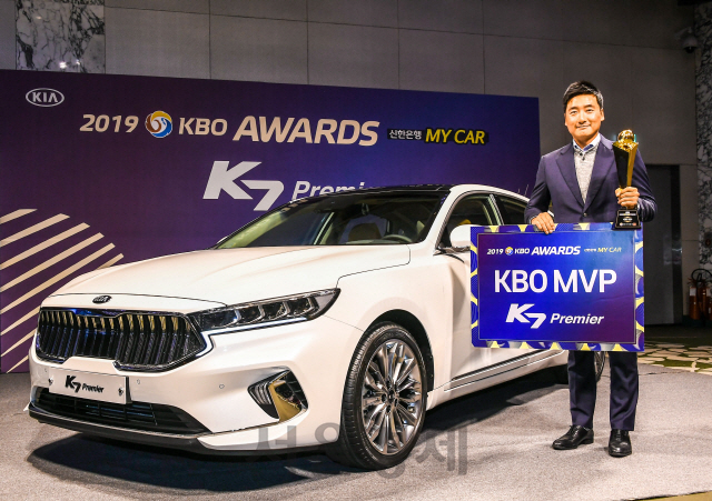 기아자동차는 25일 서울 강남구 코엑스 인터컨티넨탈 호텔에서 열린 ‘2019 신한은행 MY CAR KBO 시상식’에서 KBO리그 정규시즌 MVP로 선정된 조시 린드블럼 선수(두산 베어스)에게 부상으로 K7 프리미어를 수여했다. 해외 일정으로 불참한 린드블럼 선수를 대신해 소속팀 두산 베어스 정재훈 코치가 대리 수상을 한 뒤 기념 촬영을 하고 있다./사진제공=기아차