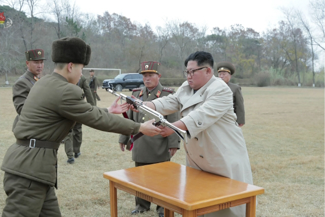 김정은 북한 국무위원장이 서부전선에 위치한 창린도 방어부대를 시찰했다고 조선중앙TV가 25일 보도했다. 사진은 조선중앙TV 화면 캡처로, 김 위원장이 한 부대원에게 총을 건네고 있다. /연합뉴스