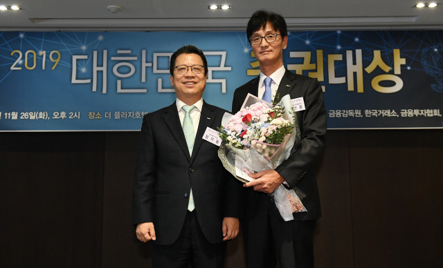 ‘2019년 대한민국 증권대상’ 시상식이 열린 26일 서울 중구 플라자호텔에서 경영혁신 부문 최우수상을 수상한 신한금융투자의 이선훈(오른쪽) 강남영업본부장이 정지원 한국거래소 이사장과 기념촬영을 하고 있다./오승현기자