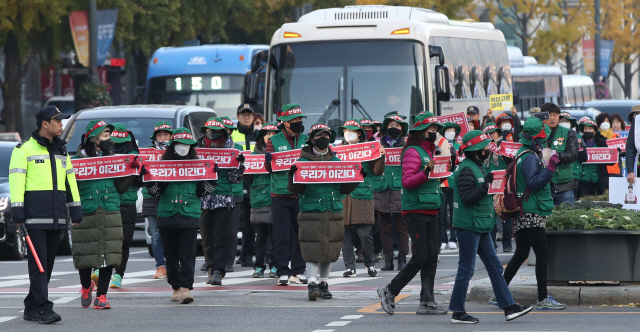 민주노총 톨게이트노조 조합원들이 12일 오전 서울 종로구 광화문 광장 인근에서 요금수납원 직고용 등을 촉구하며 행진하고 있다./연합뉴스