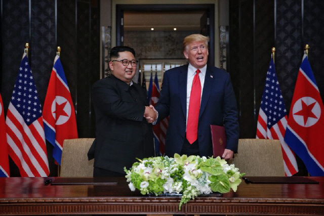 김정은 북한 국무위원장과 도널드 트럼프 미국 대통령이 지난해 6월 12일 싱가포르에서 열린 정상회담에서 공동 합의문에 서명한 후 악수를 나누고 있다./사진=공동취재단