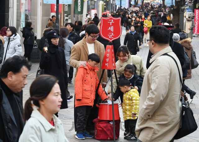 구세군 한국군이 시종식을 시작으로 전국 353곳에서 거리모금에 돌입한 29일 오후 서울 중구 명동에서 어린이가 자선냄비에 성금을 넣고 있다./오승현기자 2019.11.29