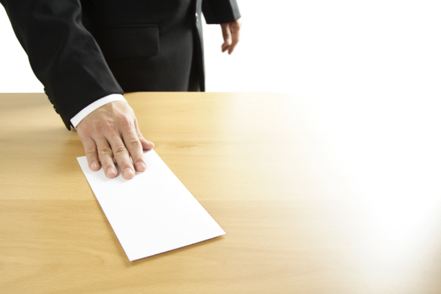 A businessman handing in a blank envelope