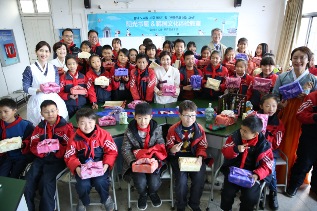 지난 29일(현지시각) 중국 절강성 항저우시 통루창업학교에서 중국 학생들과 행사 관계자들이 대한항공이 기증한 책을 들고 기념사진을 찍고 있다./사진제공=대한항공