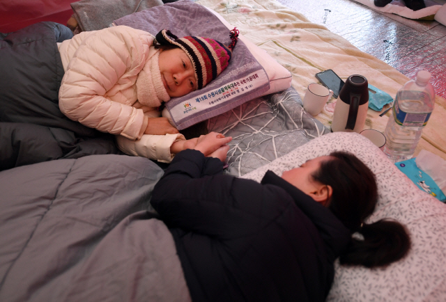 2일 청와대 사랑채 앞 투쟁 천막에서 단식 중인 자유한국당 정미경 의원(왼쪽)과 신보라 의원이 서로의 손을 잡으며 격려하고 있다./ 연합뉴스