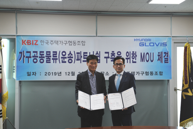 박대원(왼쪽) 주택가구협동조합 전무와 김진곤 현대글로비스 상무가 2일 공동물류협약을 맺고 협약서를 들어보이고 있다. / 사진제공=주택가구조합