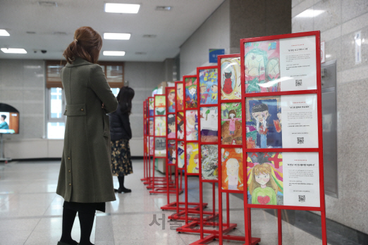 서울 성동구청에서 구민들이 아이들의 상처입은 감정을 그림으로 표현한 ‘아픈마음 그림 전시회’ 그림들을 둘러보고 있다.  /사진제공=성동구