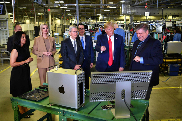도널드 트럼프(오른쪽 두번째) 미국 대통령이 지난달 20일(현지시간) 팀 쿡(왼쪽 세번째) 애플 CEO와 함께 텍사스 오스틴에 위치한 컴퓨터 제조시설을 둘러보고 있다. /오스틴=AFP연합뉴스