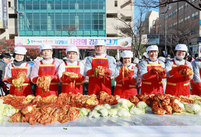 현대중공업이 5일 울산 동구 현대백화점 현대광장에서 350여명의 자원봉사자들과 함께 ‘사랑의 김장 담그기’ 행사를 열고 있다. 사진 왼쪽에서 4번째 한영석 현대중공업 사장 내외, 6번째 신현대 현대미포조선 사장 내외. /사진제공=현대중공업