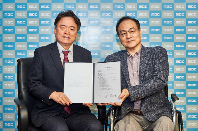 최승호(왼쪽) MBC 사장과 김환철 문피아 대표가 업무협약 후 기념 사진 촬영을 하고 있다. /사진제공=MBC