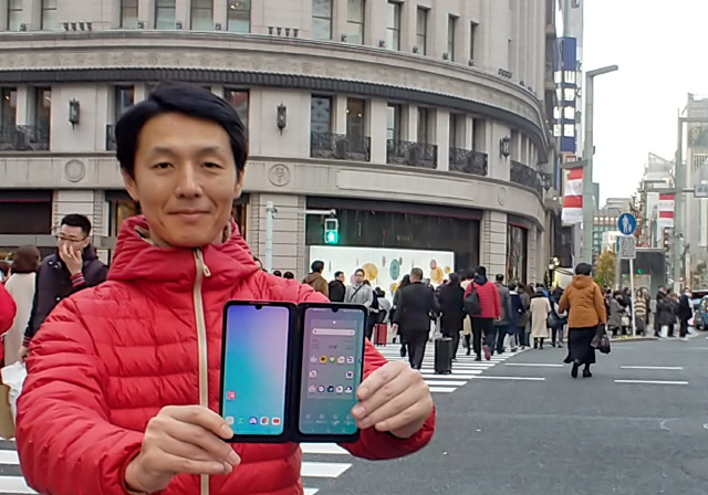 LG전자 일본법인 직원이 일본 도쿄의 유명 번화가 긴자 거리에서 G8X 씽큐를 소개하고 있다. /사진제공=LG전자