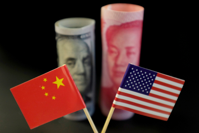 미국과 중국 국기 뒤로 양국 화폐가 보이고 있다. /로이터연합뉴스