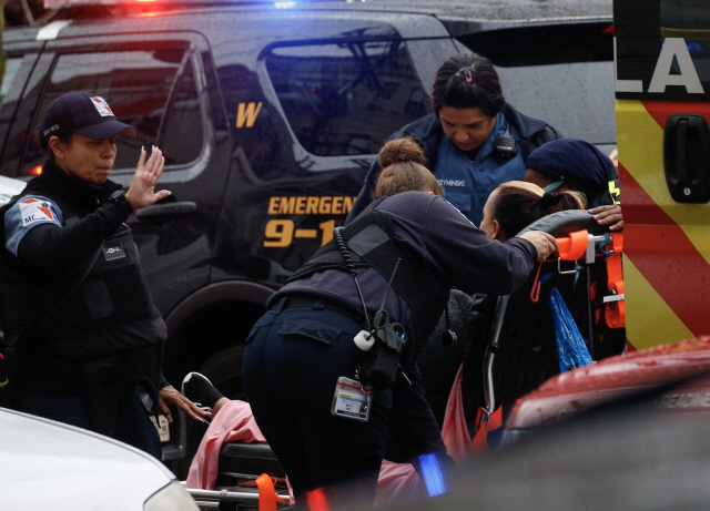 미국 뉴저지주에서 발생한 총격으로 발생한 부상자를 경찰과 응급대원들이 이송 하고 있다./저지시티=AFP연합뉴스