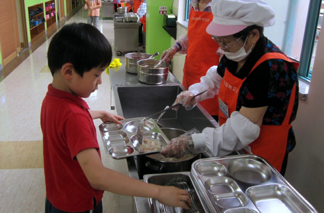 서울 서대문구 노인일자리 사업에 참여한 주민이 아이들에게 급식을 배분하고 있다.   /사진제공=서대문구