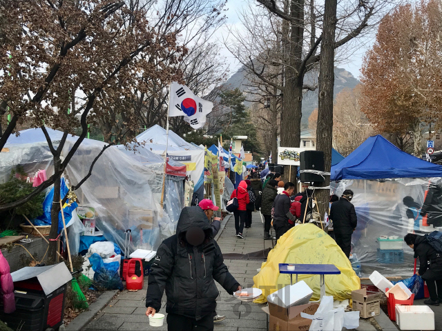 주한일본대사관 앞 소녀상을 지키는 대학생들의 농성장 천막이 11일 오후 철거돼 있다(사진 위). 같은 날 청와대 앞길에 문재인하야범국민투쟁본부(범투본)와 전국교직원노동조합 등의 천막이 인도를 차지하고 있다. /손구민 기자