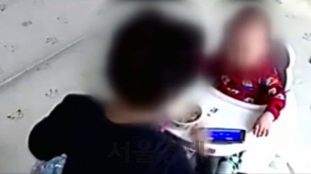 아이돌보미 김모(58)씨가 14개월 된 영아가 밥을 먹지 않는다는 이유 등으로 뺨을 때리려 하고 있다. /유튜브 갈무리