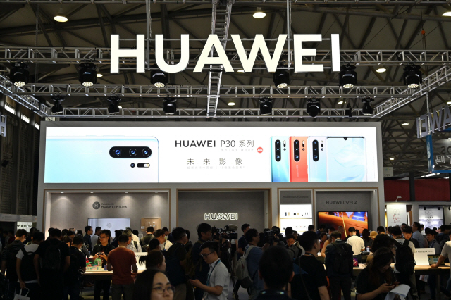 지난 6월11일(현지시간) 중국 상하이에서 열린 ‘CES 아시아 2019’에서 사람들이 화웨이 제품을 보고 있다. /상하이=AFP연합뉴스