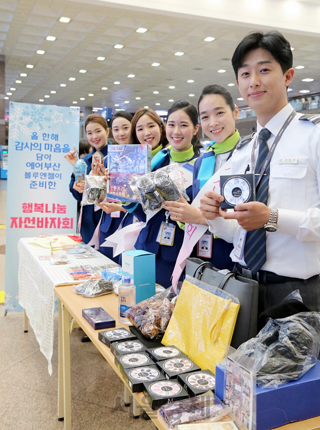 13일 김해국제공항에서 열린 ‘행복 나눔 자선 바자회’에서 에어부산 승무원들이 판매하는 제품을 들고 포즈를 취하고 있다. /사진제공=에어부산