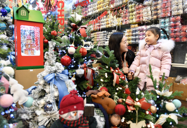 크리스마스를 앞둔 8일 서울 남대문시장을 찾은 한 가족이 상점에 진열된 크리스마스 조명, 장식과 트리를 보며 환하게 웃고 있다./권욱기자