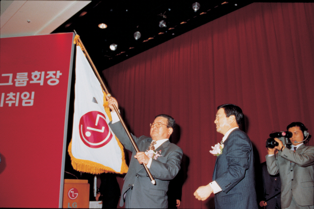 구자경(왼쪽) LG그룹 명예회장이 1995년 회장 이취임식에서 고 구본무 회장에게 LG 깃발을 전달하고 있다.  /사진제공=LG