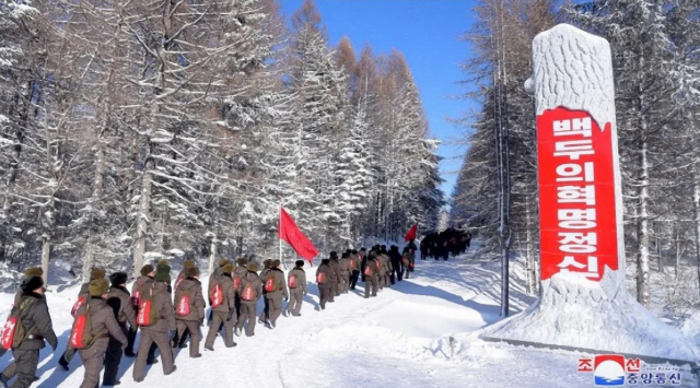 북한 전국당선전 일꾼(간부)들이 지난 14일 삼지연 혁명전적지를 답사했다고 조선중앙통신이 15일 보도했다. 간부들이 눈 덮인 산을 오르고 있다./연합뉴스