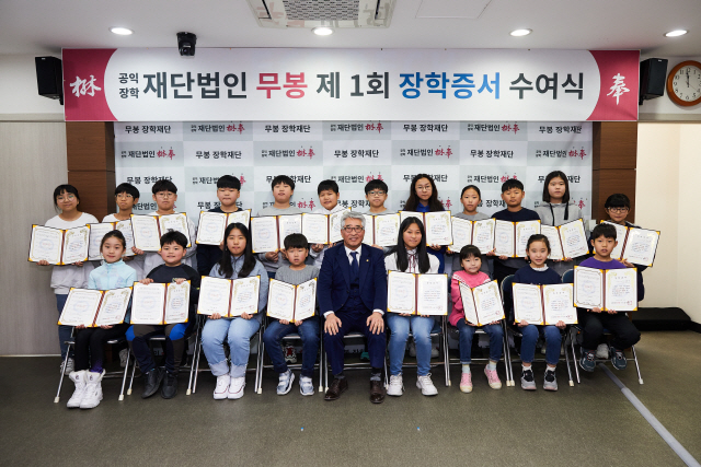 김명환 덕신하우징 회장이 14일 서울 사옥에서 열린 제1회 무봉장학생 장학증서 수여식에서 장학생들과 기념사진을 촬영하고 있다. / 사진제공=덕신하우징