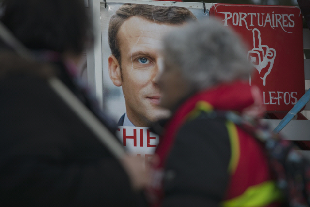 14일(현지시간) 남프랑스 마르티그에서 연금개편 저지 결의대회가 벌어지고 있는 가운데 에마뉘엘 마크롱 대통령의 포스터가 벽에 걸려 있다. /마르티그=AP연합뉴스