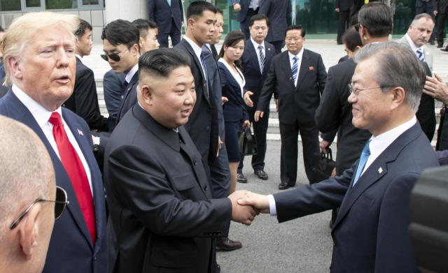 지난 6월30일 문재인 대통령과 김정은 북한 국무위원장이 판문점 남측 자유의 집 앞에서 악수를 하고 있고 도널드 트럼프 대통령이 지켜보고 있다./연합뉴스