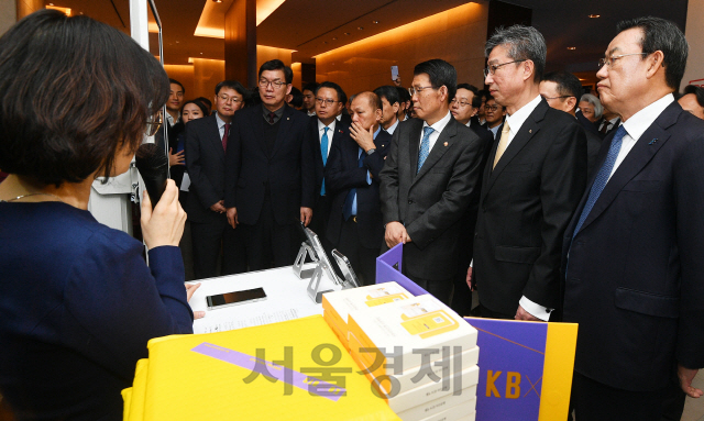 은성수 금융위원장을 비롯한 금융 관계자들이 18일 오전 서울 중구 웨스틴조선호텔에서 열린 ‘오픈뱅킹 서비스 출범식’에 참석해 KB국민은행의 오픈뱅킹 활용 서비스 시연을 보고 있다./오승현기자 2019.12.18