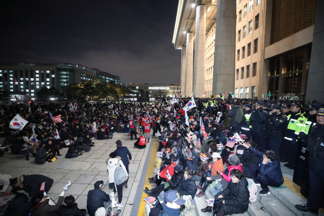 16일 오후 서울 여의도 국회 본청 앞에서 ‘패스트트랙 법안 날치기 상정 저지 규탄대회’에 참가했던 보수단체 회원들이 ‘공수처법 폐기 및 선거법 날치기 중단’을 요구하며 집회를 이어가고 있다. /연합뉴스