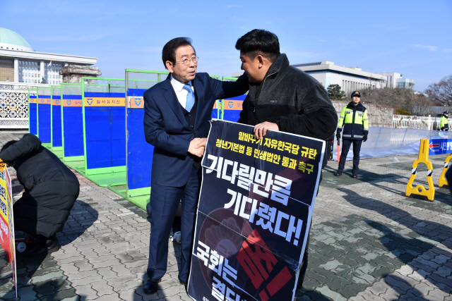 박원순(왼쪽) 서울시장이 18일 국회 앞에서 청년기본법 제정 촉구를 위해 피켓시위를 하고 있는 청년을 찾아 응원하고 있다.    /사진제공=서울시