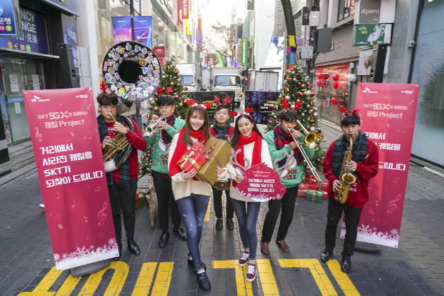 SK텔레콤 모델들이 19일 서울 명동에서 소상공인에게 한 달간 매장용 음원을 무료로 제공하는 ‘캐럴이 돌아왔다’ 프로젝트를 알리고 있다. SK텔레콤과 음원서비스 ‘플로’는 자영업자와 소상공인에게 음원서비스 1개월 이용권을 제공하고, 매장 면적이나 업종에 따라 음원 권리자에게 지불하는 저작권료를 전액 해결하기로 했다./사진제공=SK텔레콤