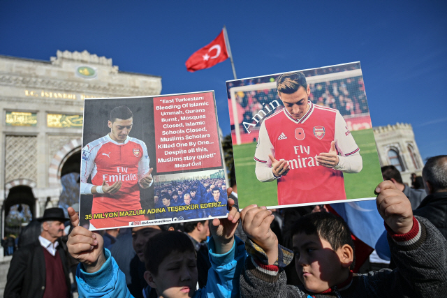 지난 14일(현지시간) 터키 이스탄불에서 중국 신장지역 무슬림 지지자들이 축구선수 메주트 외질 사진이 담긴 플래카드를 들어보이고 있다./이스탄불=AFP연합뉴스