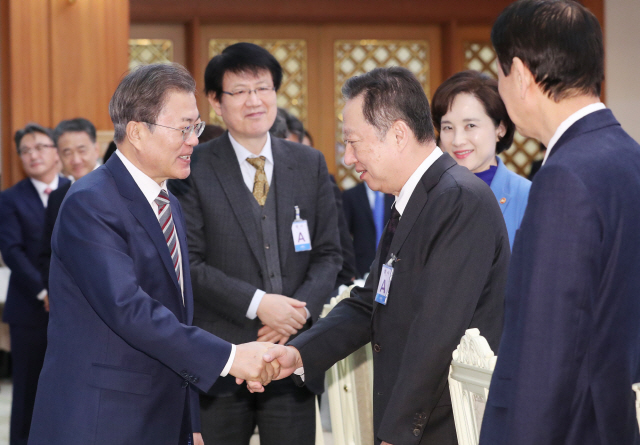 문재인 대통령이 19일 청와대에서 확대경제장관회의에 참석한 박용만 대한상의 회장과 인사하고 있다. 정부는 내년에 민간기업들이 25조원 이상을 공장 증설 등에 앞당겨 투자할 수 있도록 지원하기로 했다.  /연합뉴스