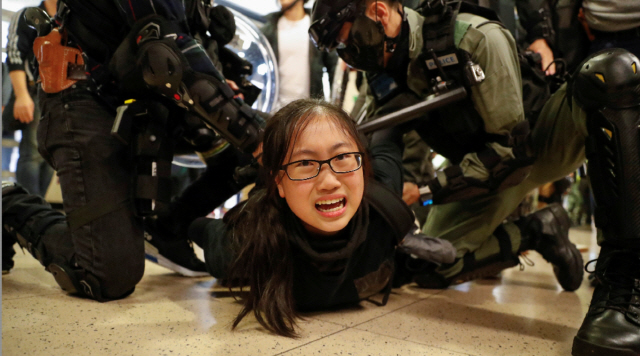 홍콩 경찰이 15일 한 쇼핑몰 내부에서 반정부 시위를 벌이던 시민을 붙잡고 있다./연합뉴스