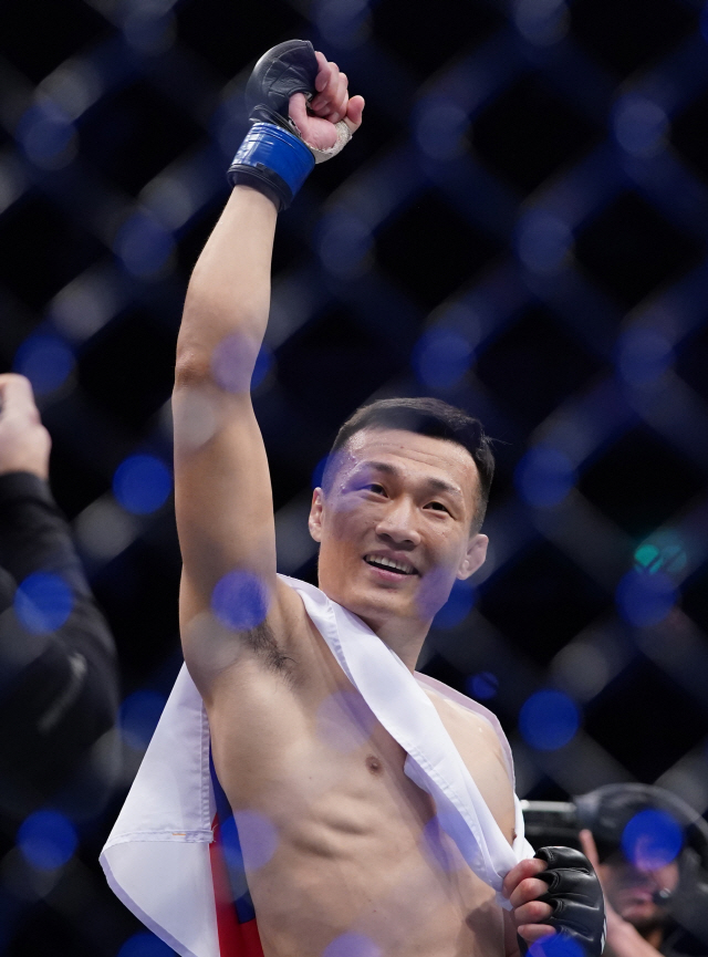 정찬성이 지난 21일 UFC 파이트 나이트 부산 메인 이벤트에서 프랭키 에드가를 꺾은 뒤 태극기를 두른 채 세리머니를 하고 있다. /부산=펜타프레스연합뉴스